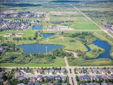 Ortasında büyük bir su kütlesi olan yerleşim yeri manzarası. Su ağaçlar ve evlerle çevrili.