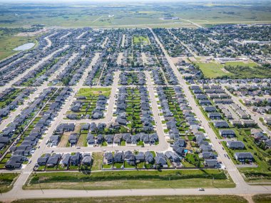 Birçok evi ve birkaç arabası olan bir yerleşim yeri. Evlerin çoğu beyaz ve cadde ağaçlarla kaplı.