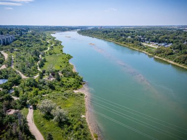 Yeşilimsi renkli bir nehir ve arka planda birkaç ağaç. Su sakin ve huzurlu.