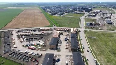 Ortasında büyük boş bir arsa olan bir şehir manzarası. Arazi binalar ve bir yol ile çevrili.