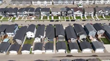 Önlerinde bir sürü araba olan bir sürü ev. Evlerin hepsi siyah beyaz.