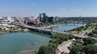 Üzerinden nehir akan ve üzerinde köprü olan bir şehir. Köprü büyük bir köprüdür ve ağaçlarla çevrilidir. Şehir trafik ve insanlarla dolup taşıyor.