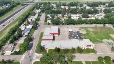 Okulu ve kilisesi olan bir yerleşim yeri manzarası. Binalar kırmızı ve beyaz.