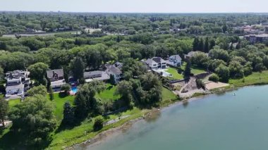 Sahilde evi olan güzel bir göl. Ev ağaçlarla çevrili ve bir havuzu var.