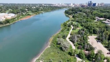 Kıyısında yeşil orman olan bir nehir. Su sakin ve ağaçlar yemyeşil