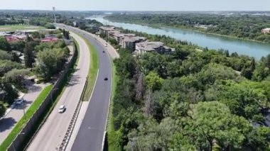 Nehir üzerinde köprüsü olan bir otoyol. Köprü yapım aşamasında. Yolda arabalar var.