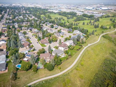 Evleri ve parkı olan bir yerleşim yeri. Evlerin çoğu beyaz ve park yeşil.