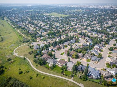 Evleri ve parkı olan bir yerleşim yeri. Evler dağılmış durumda ve bölgede bir sürü ağaç var.