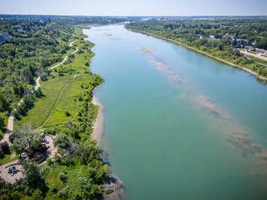 Yeşilimsi bir rengi ve yanında uzanan bir yolu olan bir nehir. Su sakin ve huzurlu.