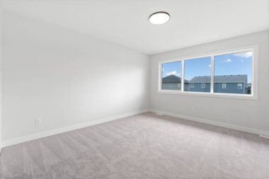 Büyük, penceresi ve aydınlatma armatürü olan boş bir oda. Oda çok temiz ve havadar bir havası var.