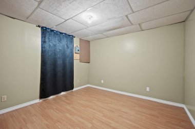 Room with a blue curtain and a white wall. The room is empty and has a simple design