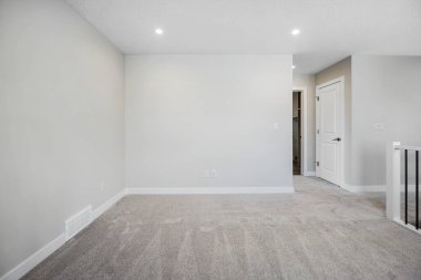 Beyaz duvarı ve beyaz kapısı olan beyaz bir oda. Oda boş ve minimalist bir görünüşü var.