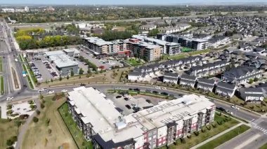 4K aerial view of Stonebridge in Saskatoon, showing modern homes, parks, and busy retail areas in this southside community.