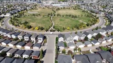 4K aerial view of Stonebridge in Saskatoon, showing modern homes, parks, and busy retail areas in this southside community.
