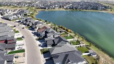 4K aerial view of Stonebridge in Saskatoon, showing modern homes, parks, and busy retail areas in this southside community.