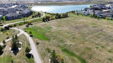 4K aerial view of Stonebridge in Saskatoon, showing modern homes, parks, and busy retail areas in this southside community.