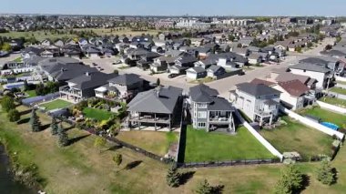 4K aerial view of Stonebridge in Saskatoon, showing modern homes, parks, and busy retail areas in this southside community.