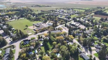4K aerial view of Waldheim, Saskatchewan, showcasing homes, schools, churches, and surrounding prairie farmland.