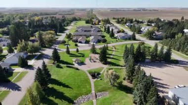 4K aerial view of Waldheim, Saskatchewan, showcasing homes, schools, churches, and surrounding prairie farmland.
