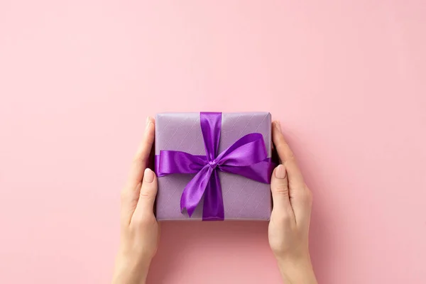 新年的概念 第一人称头像女用手送给紫带蝴蝶结紫丁香礼盒的照片 — 图库照片