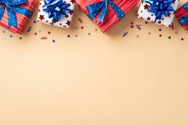 4 Temmuz kutlama konsepti. Mevcut kutuların ulusal bayrak renklerinde üst görünüm fotoğrafı ve izole edilmiş bej arka planda boş alan konfetisi