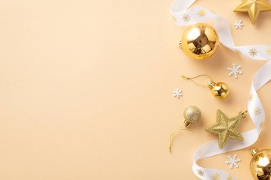 Noel ağacı süslemeleri konsepti. Altın takılar yıldız süslemeleri beyaz kıvrımlı kurdele ve kar taneleri izole edilmiş bej arkaplan ve boş alan