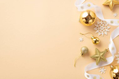 Yeni yıl konsepti. Altın takılar yıldız süslemeleri beyaz kıvrımlı kurdele ve kar tanesi süslemeleri izole edilmiş bej arkaplan ile telif alanı