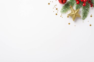 Yeni yıl konsepti. Kırmızı takılar takılarak süslenmiş köknar dalının en üstteki fotoğrafı ökseotu meyveleri ve izole edilmiş beyaz arka planda parlayan konfetiler.