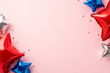 4 Temmuz kutlama konsepti. Ulusal bayrak renklerinde yıldız şekilli balonların ve kopyalanmış pembe arka planda parlak konfetilerin üst görünümü