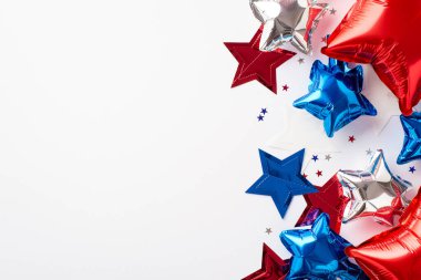 ABD Bağımsızlık Günü dekorasyon konsepti. Kırmızı mavi balonların en üstteki fotoğrafı yıldız çelengi ve boş arkaplan üzerine konfeti.