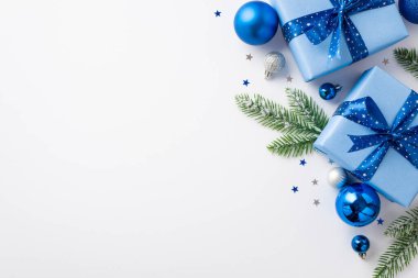Noel Günü konsepti. Mavi beyaz mücevher kutuları, kardaki köknar dalları ve izole edilmiş beyaz arka plandaki konfetileri gösteren mavi beyaz mücevher kutuları.