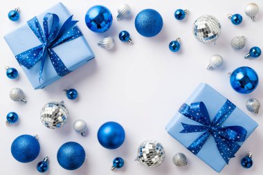 Noel arifesi kavramı. Mavi beyaz takılar disko topları ve ortasında kopyalanmış beyaz arkaplan üzerinde kurdele ile büyük hediye kutuları üst görünüm fotoğraf