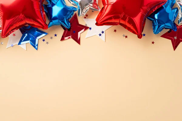 USA Independence Day decor concept. Top view photo of balloons in national flag colors star garland and confetti on isolated beige background with empty space