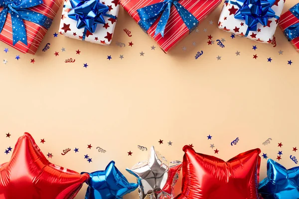 USA Independence Day decoration concept. Top view photo of present boxes balloons in national flag colors and confetti on isolated beige background with blank space