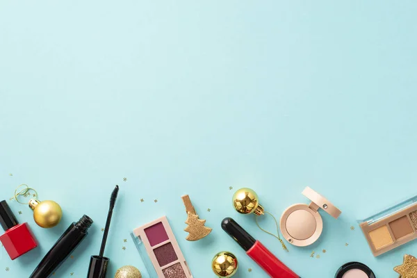 stock image Christmas season concept. Top view photo of decorative cosmetics lip gloss nail polish mascara eyeshadow palettes golden baubles ornaments sequins on isolated pastel blue background with copyspace