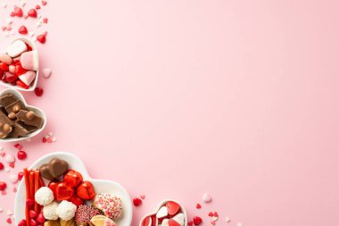 Sevgililer Günü kutlaması konsepti. Kalp şeklindeki çanak çömleğin üst görüntüsü şekerleme ile izole edilmiş pastel pembe arka planda kopyalanmış