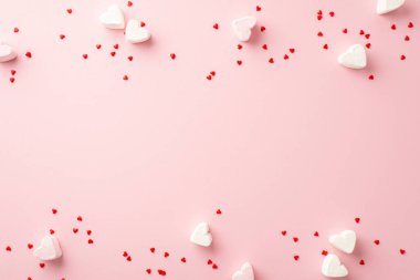 Sevgililer Günü konsepti. İzole edilmiş pastel pembe arkaplandaki küçük kalp şekilli şekerlemelerin üst görünümü