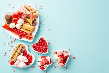 Sevgililer Günü atmosfer konsepti. Kalp şeklindeki tabakları şekerli kurabiyeler ve konfetilerin izole edilmiş açık mavi arka planda boş alandaki en iyi görüntüsü.