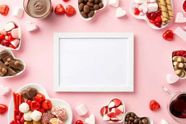 stock image Valentine's Day concept. Top view photo of white photo frame heart shaped plates with sweets candies and glasses with drinking on isolated light pink background with empty space