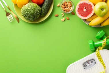 Diyet konsepti. Sebzeli tabaklar, fındıklı fındıklı fotoğraf. Mezuraları ve dambılları ölçer. İzole edilmiş yeşil arkaplandaki dambıllar.