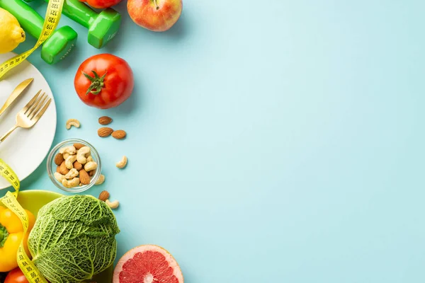 Stock image Proper nutrition concept. Top view photo of plate cutlery tomato cabbage pepper grapefruit nuts apple dumbbells and tape measure on isolated pastel blue background with empty space