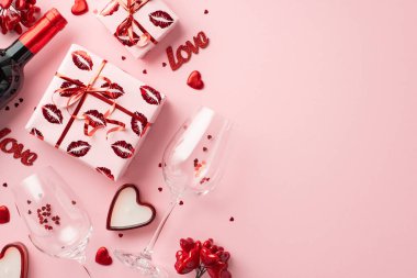 Sevgililer Günü konsepti. En üstteki resimde şarap şişesi konfeti kalp şeklinde mumlar ve yazıtlarla dolu iki bardak kopyalanmış pastel pembe arka planda aşk var.