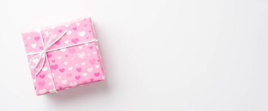 Sevgililer Günü konsepti. Üst görünüm fotoğraf pembe hediye kutusu ambalaj kağıdında kalp deseni izole beyaz arkaplan ile kopyalanmış