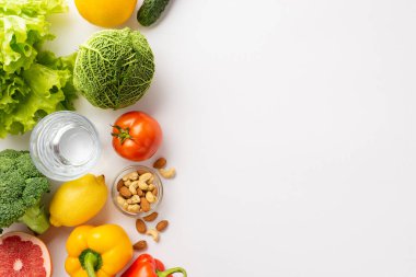 Uygun beslenme konsepti. Sebze, fındık ve bir bardak suyun izole edilmiş beyaz arka planda çekilmiş en iyi fotoğrafı.