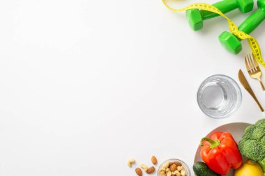 Uygun diyet konsepti. Dambılların en üstteki fotoğrafı sebzeli mezura çan biberi karnabahar fındık kabuğu izole edilmiş beyaz arka planda su ve çatal bıçak seti.