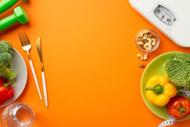 Kilo verme konsepti. Dambılların en üstteki fotoğrafında mezura, biber kabuğu, karnabahar, çatal bıçak takımı ve izole edilmiş turuncu arka planda bir bardak su.