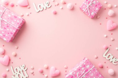 Sevgililer Günü konsepti. Hediye kutularının en üstteki fotoğrafı kalp şeklinde mumlar aşk serpintileri ve yumuşak ponponlar izole edilmiş pastel pembe arka planda ortada kopyalanmış alan