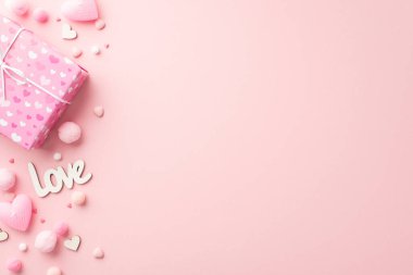 Sevgililer Günü konsepti. Şık hediye kutusu kalp şeklindeki mumların en üstteki fotoğrafı. Yazı, aşk serpintileri ve izole edilmiş, pembe arkaplanlı yumuşak püsküllü ponponlar.