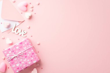 Sevgililer Günü konsepti. Kağıt kalp şekilli marshmallow yazıtlı hediye kutusu zarfının en üstteki fotoğrafı izole edilmiş pastel pembe arka planda kopyalanmış aşk ve serpintiler.