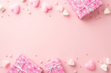 Sevgililer Günü konsepti. Hediye kutularının, kalp şeklindeki şekerlemelerin, mumların ve izole edilmiş açık pembe arka planda serpiştirmelerin en üstteki fotoğrafı.